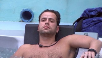 Pensativo, Gustavo relaxa sozinho na hidromassagem da casa