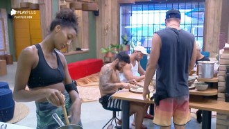 Peões cantam na cozinha, enquanto preparam o almoço da sede