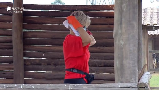 Com lenço no nariz por causa do cheiro, Andréa limpa chiqueiro