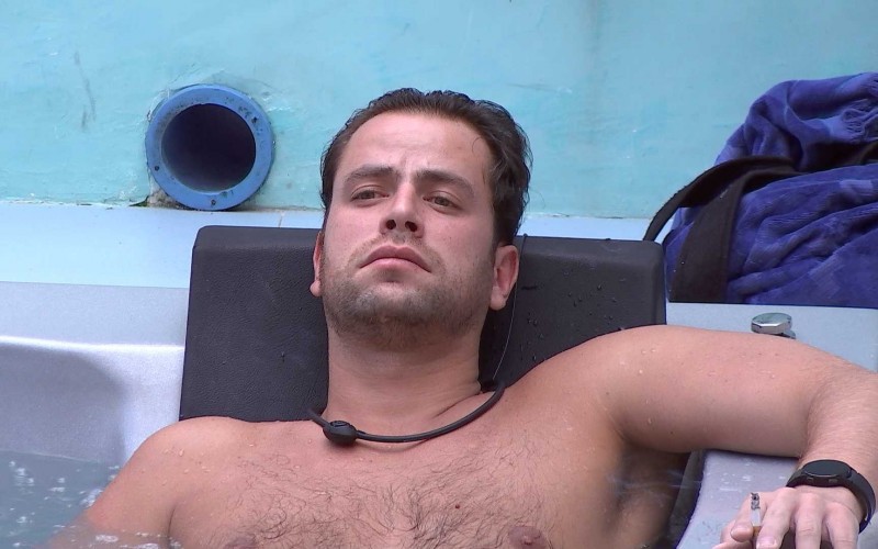 Pensativo, Gustavo relaxa sozinho na hidromassagem da casa