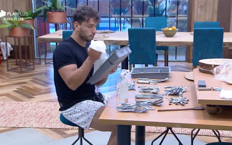 Lucas Viana acorda cedo e limpa talheres na cozinha da sede